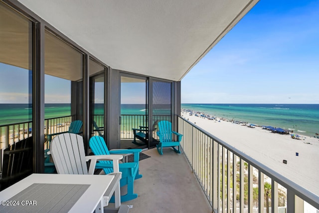 balcony featuring a view of the beach and a water view