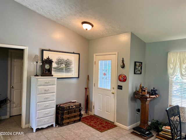 foyer with light tile patterned flooring and a textured ceiling