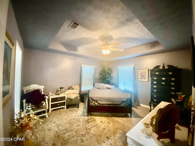 bedroom featuring ceiling fan and a raised ceiling