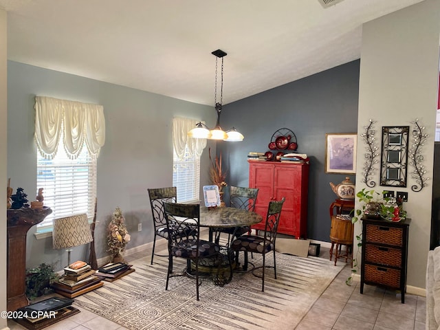 tiled dining room with an inviting chandelier