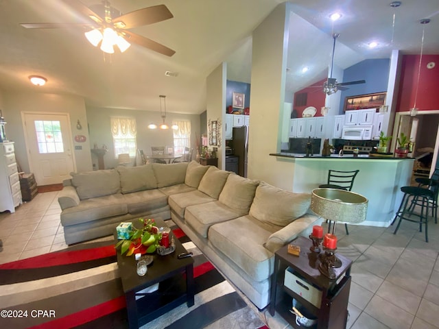 tiled living room featuring ceiling fan and vaulted ceiling