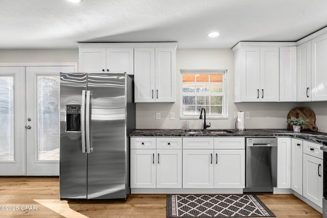 kitchen with sink, dishwashing machine, white cabinets, and stainless steel fridge with ice dispenser