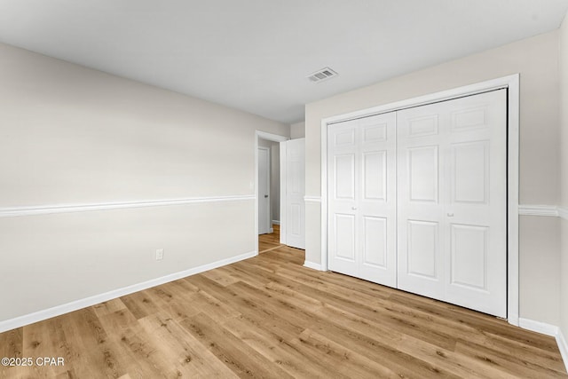 unfurnished bedroom featuring a closet and light wood-type flooring