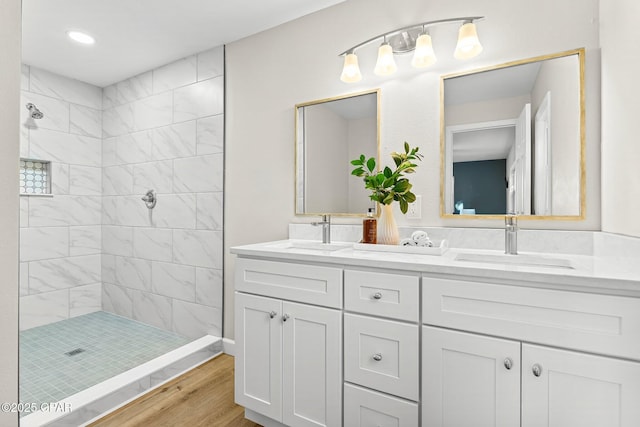 bathroom featuring vanity, tiled shower, and hardwood / wood-style flooring