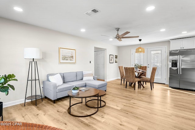 living room with light wood-type flooring and ceiling fan