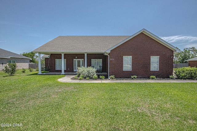 view of front of home with a front yard, fence, and brick siding