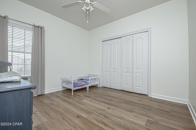 unfurnished bedroom featuring multiple windows, a closet, ceiling fan, and light hardwood / wood-style floors