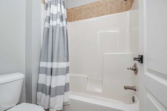 bathroom featuring shower / bath combination with curtain and toilet