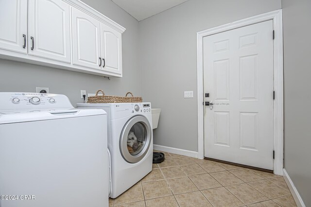 laundry area featuring cabinets, washer and clothes dryer, and light tile patterned floors