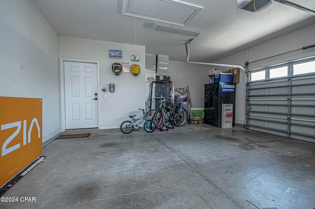 garage with black fridge with ice dispenser and a garage door opener