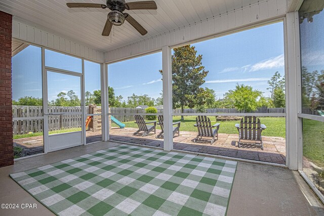 unfurnished sunroom featuring ceiling fan