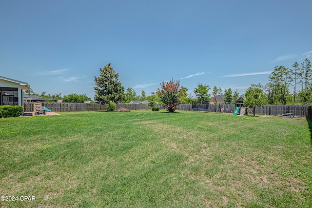 view of yard with a trampoline and a playground