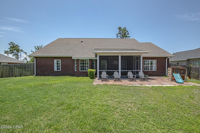 back of house with a sunroom and a lawn