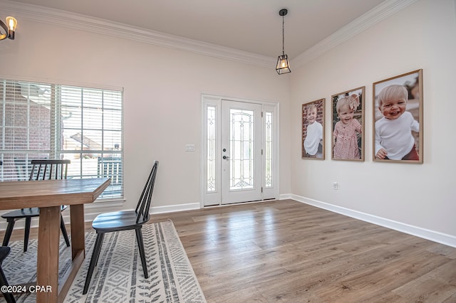 entryway with a wealth of natural light, crown molding, and hardwood / wood-style flooring