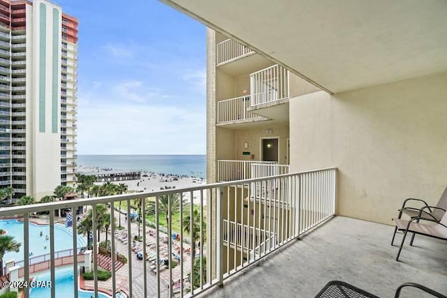 balcony featuring a view of the beach and a water view