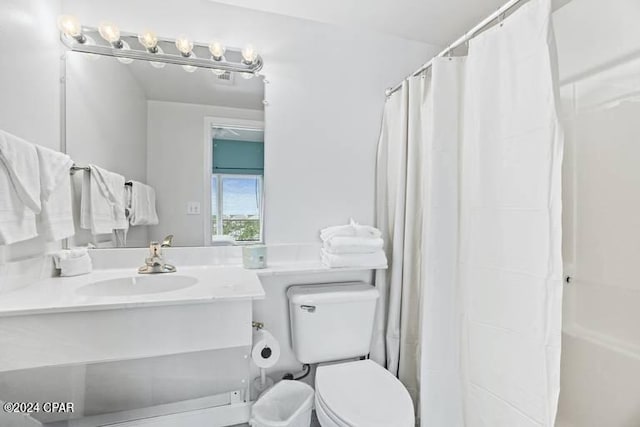 bathroom featuring curtained shower, vanity, and toilet