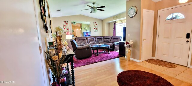 foyer entrance with vaulted ceiling, a ceiling fan, wood finished floors, baseboards, and visible vents
