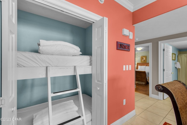 bedroom with light tile patterned floors and crown molding