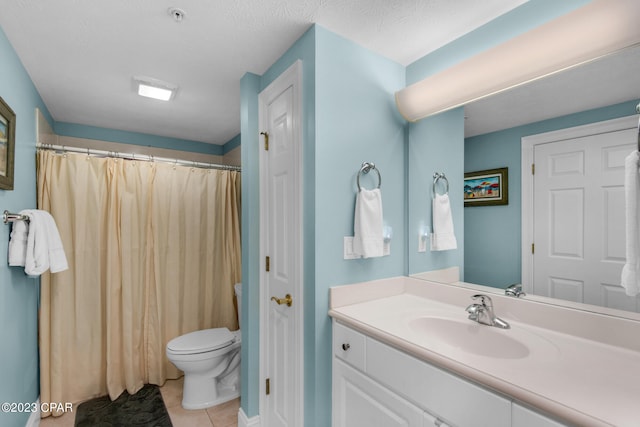 bathroom featuring vanity, toilet, tile patterned floors, and a textured ceiling