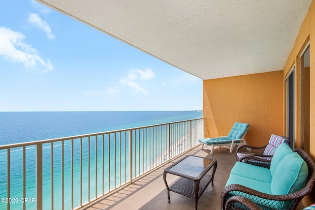 balcony featuring a water view and a view of the beach