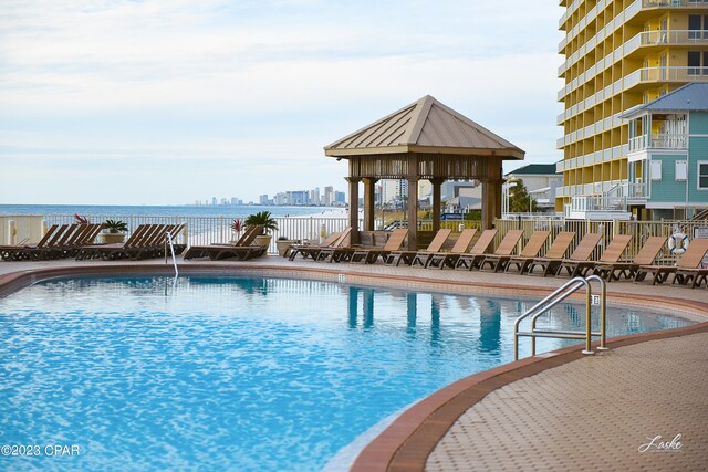 view of swimming pool featuring a gazebo and a water view