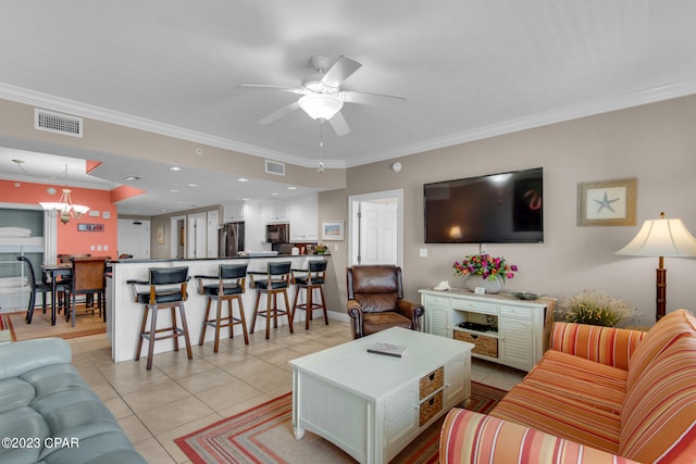 living room with ceiling fan with notable chandelier, crown molding, and light tile patterned flooring