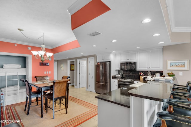 kitchen featuring pendant lighting, light tile patterned floors, a breakfast bar, appliances with stainless steel finishes, and white cabinets