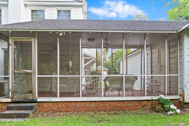 exterior space with roof with shingles and a sunroom