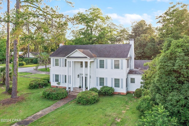 neoclassical home featuring a chimney, crawl space, and a front yard