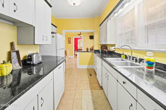 kitchen with white cabinetry, sink, dark stone countertops, light tile patterned flooring, and ornamental molding