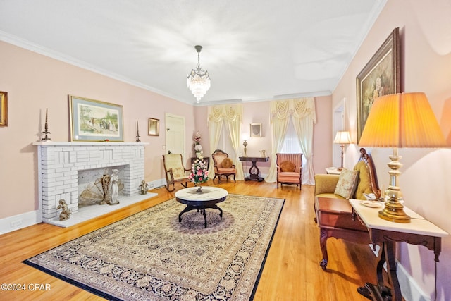 living room featuring wood finished floors, a brick fireplace, a chandelier, and crown molding