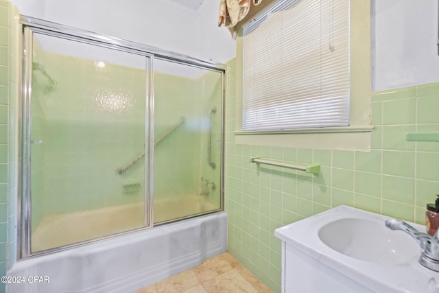 703 N Waukesha St, Bonifay, FL 32425 - full bathroom featuring tile walls, bath / shower combo with glass door, vanity, and tile patterned flooring