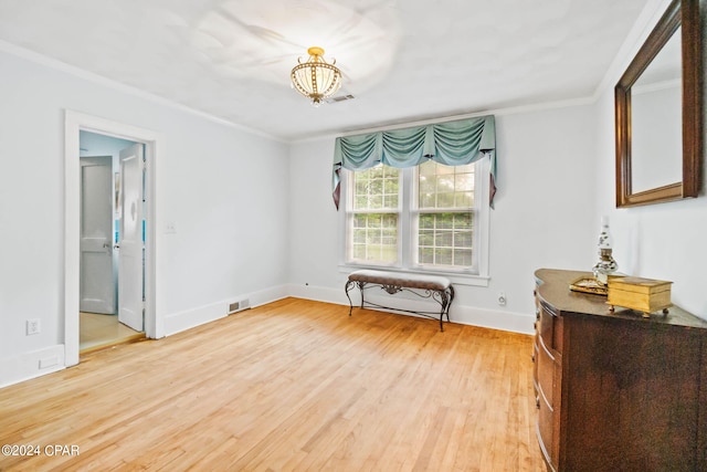 unfurnished room featuring light wood-type flooring and crown molding