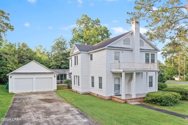 view of front of home featuring a garage, a balcony, an outdoor structure, and a front yard