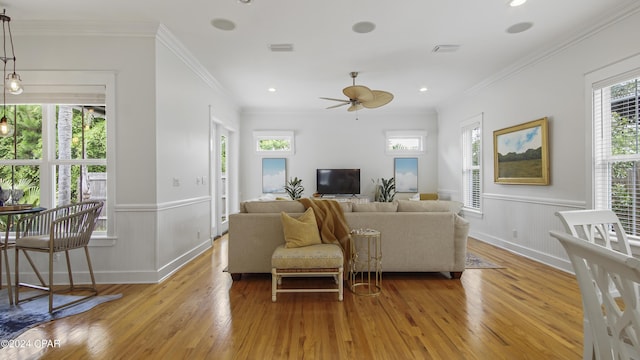 living room featuring light wood-type flooring, ceiling fan, and ornamental molding