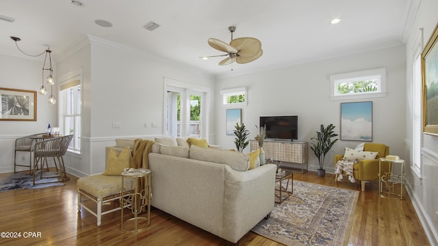 living room featuring dark wood-type flooring, ceiling fan, and ornamental molding