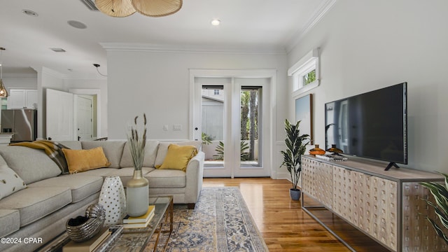 living room featuring ceiling fan, light hardwood / wood-style flooring, and ornamental molding