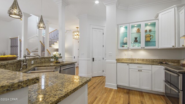 kitchen featuring decorative light fixtures, sink, white cabinets, and appliances with stainless steel finishes