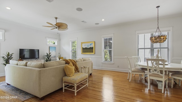 living room featuring crown molding, ceiling fan with notable chandelier, and hardwood / wood-style flooring