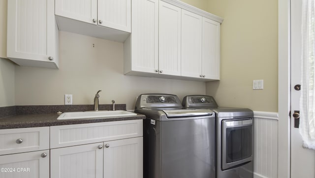 washroom with cabinets, sink, and washing machine and dryer