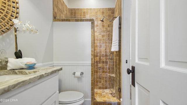 bathroom with toilet, vanity, and a shower with door