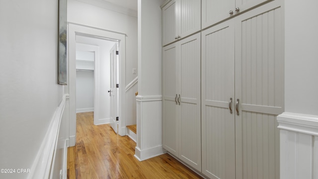 corridor featuring crown molding and light hardwood / wood-style floors