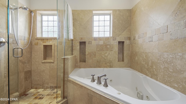 bathroom featuring independent shower and bath and tile walls