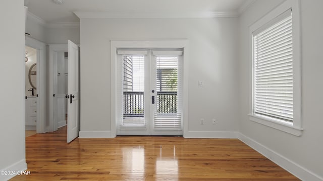 spare room with light wood-type flooring and ornamental molding