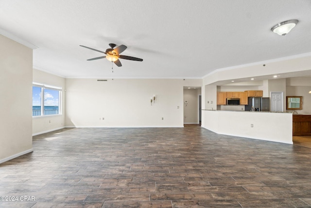 unfurnished living room featuring dark hardwood / wood-style flooring, a textured ceiling, ceiling fan, crown molding, and a water view