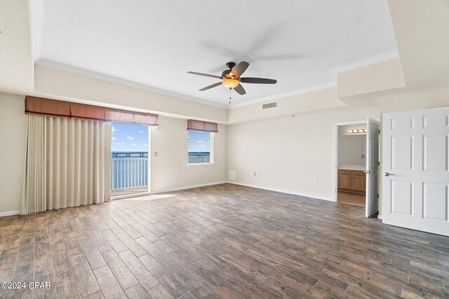 spare room with a textured ceiling, ceiling fan, dark hardwood / wood-style floors, and ornamental molding