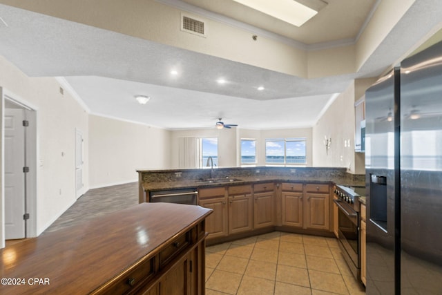 kitchen featuring visible vents, a peninsula, stainless steel appliances, crown molding, and a sink