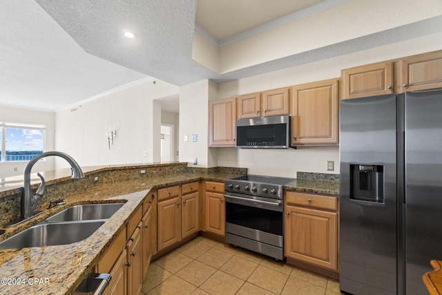 kitchen featuring light tile patterned flooring, stainless steel appliances, a sink, dark stone countertops, and crown molding