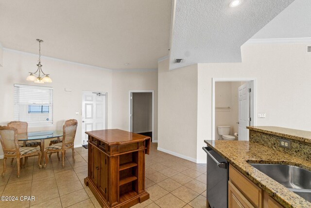 kitchen featuring a textured ceiling, crown molding, pendant lighting, light tile patterned floors, and dishwasher