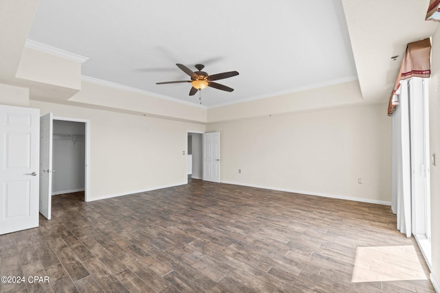 unfurnished bedroom featuring a raised ceiling, crown molding, baseboards, and wood finished floors